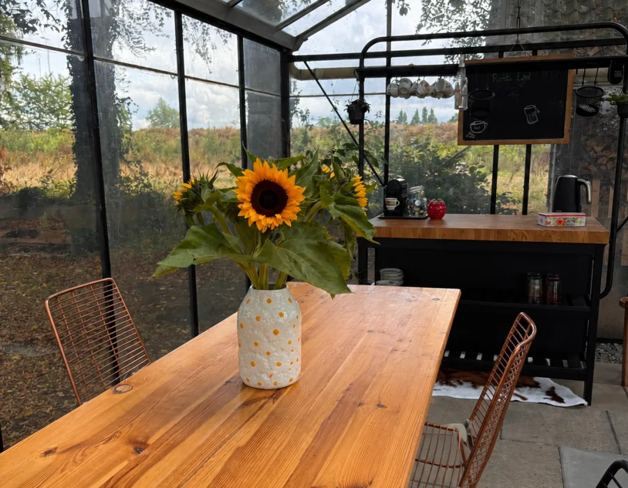 Lichte vergaderruimte met een lange houten tafel en uitzicht op het groen