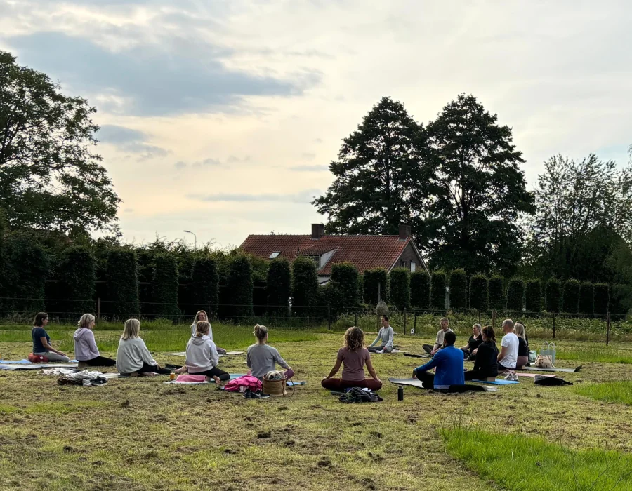 Kleinschalige yogasessie op het gras in warm avondlicht